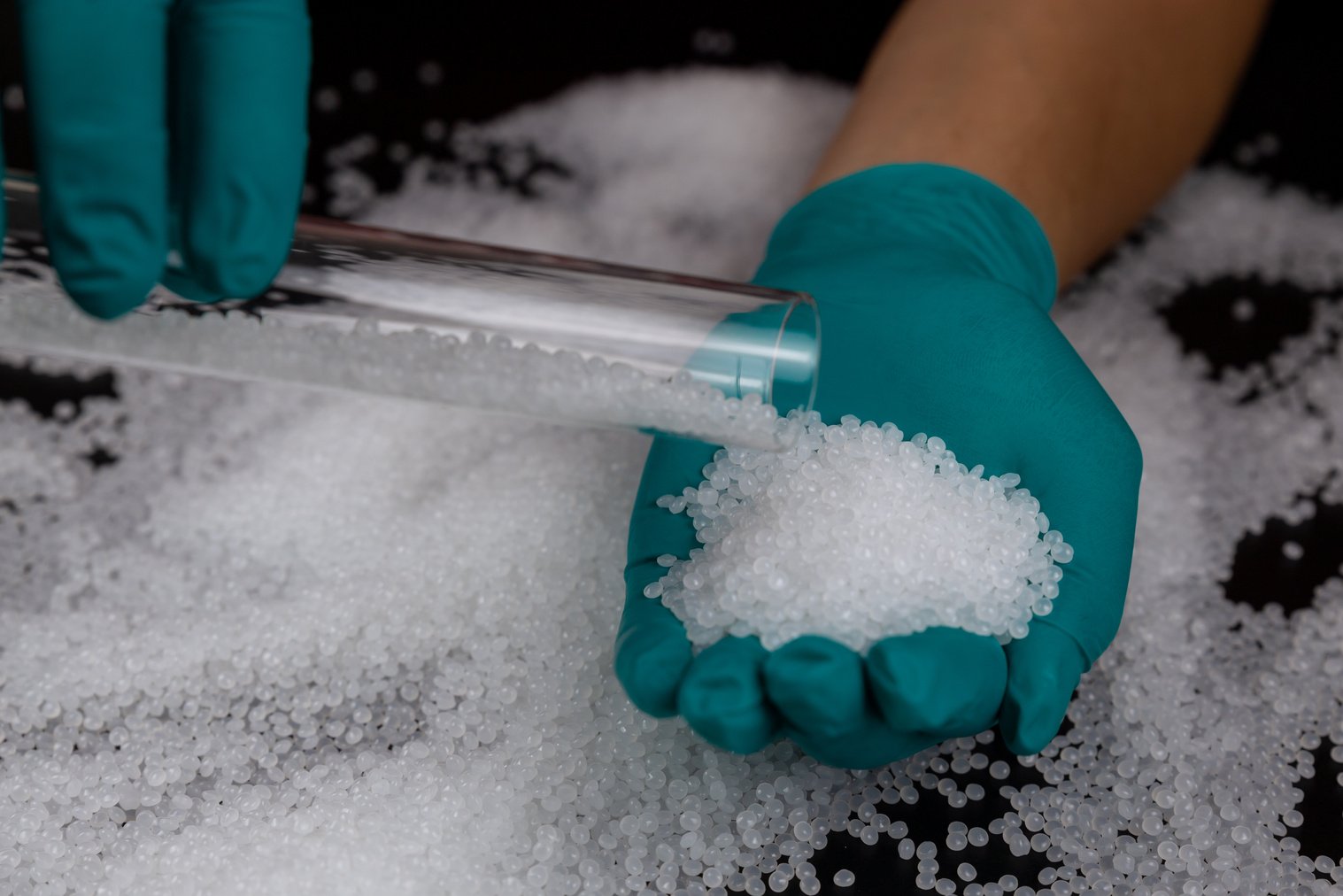 Close-up of plastic polymer granules. hand hold Polymer pellets. polymer plastic. compound polymer. Hands in rubber gloves hold plastic pellets.